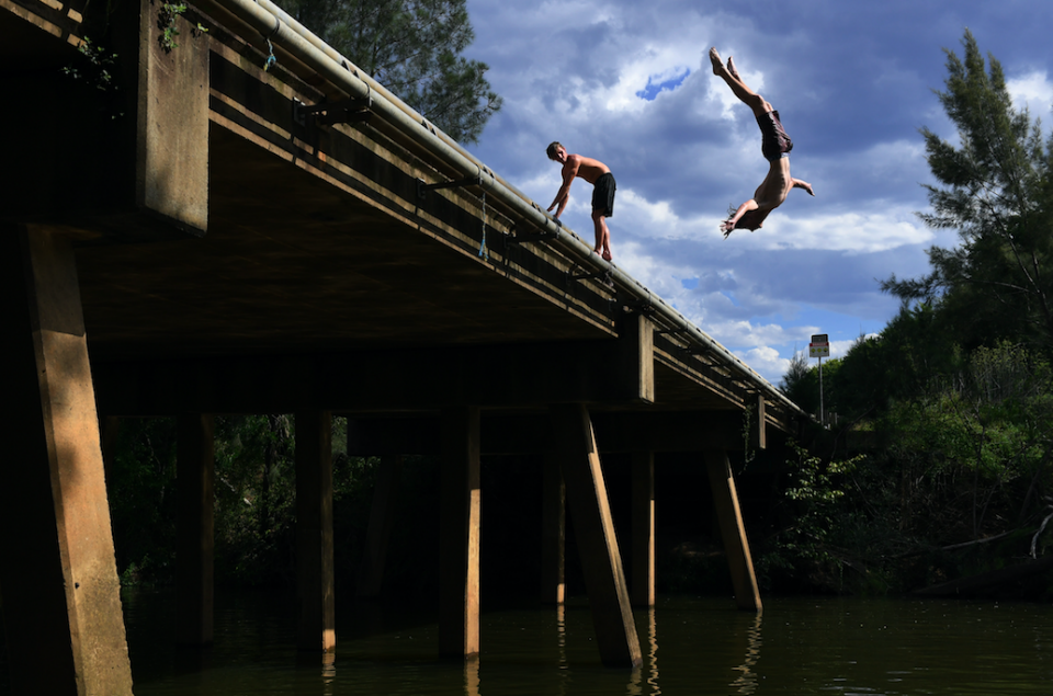 Boys jump into the Nepean River as the temperature exceeded 45 degrees celsius in western Sydney on Saturday. Photo: AAP