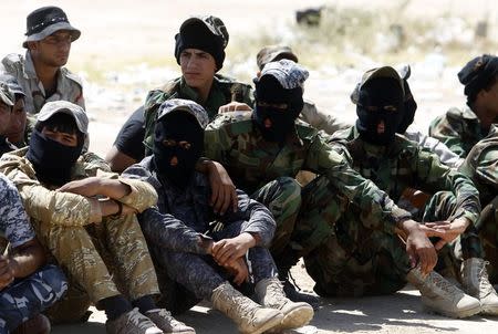 Shi'ite volunteers, who have joined the Iraqi army to fight against militants of the Islamic State, formerly known as the Islamic State of Iraq and the Levant (ISIL), sit together during training in Baghdad, July 9, 2014. REUTERS/Ahmed Saad