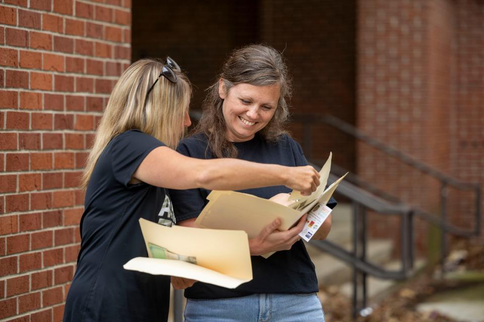 Kenmore High School class of 1996 alumni and former class president Pam Rockich, right, reacts to seeing what she placed inside a time capsule 28  years ago.