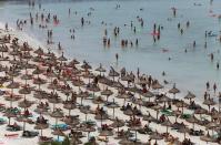 Tourists crowd Palma de Mallorca's Arenal beach on the Spanish Balearic island of Mallorca July 25, 2014. REUTERS/Enrique Calvo/File Photo