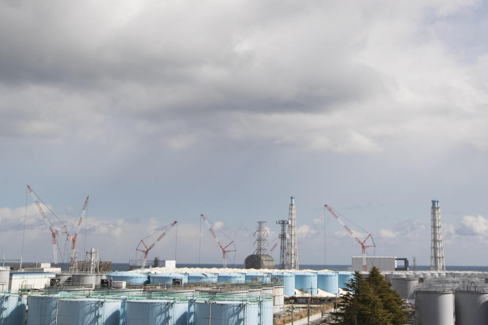 Nuclear reactors of No. 1, from left, 2, 3 and 4 look over tanks storing water that was treated but still radioactive, at the Fukushima Daiichi nuclear power plant in Okuma town, Fukushima prefecture, northeastern Japan, Saturday, Feb. 27, 2021. (AP Photo/Hiro Komae)