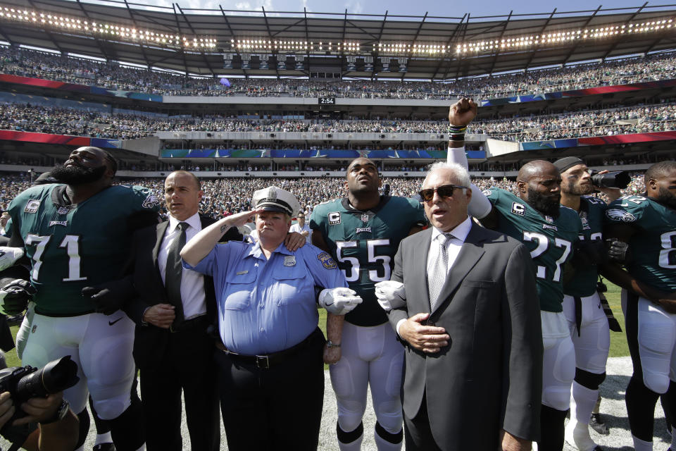 <p>Philadelphia Eagles players and owners Jeffrey Lurie stand for the national anthem before an NFL football game against the New York Giants, Sunday, Sept. 24, 2017, in Philadelphia. Eagles’ Malcolm Jenkins is seen raising his fist next to Lurie. (AP Photo/Matt Rourke) </p>