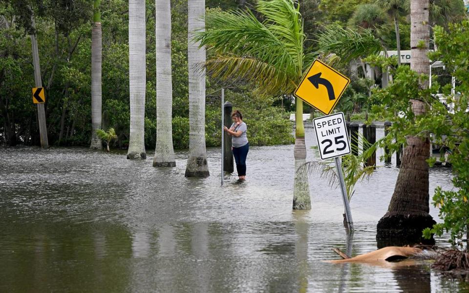 A woman takes photos on her phone near Wares Creek after Hurricane Idalia passed on August 30, 2023.