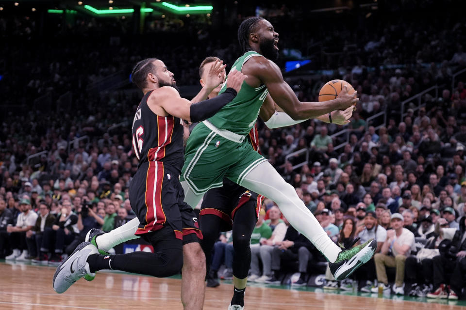 Boston Celtics guard Jaylen Brown, right, drives to the basket against Miami Heat's Caleb Martin (16) during the first half of Game 2 of an NBA basketball first-round playoff series, Wednesday, April 24, 2024, in Boston. (AP Photo/Charles Krupa)