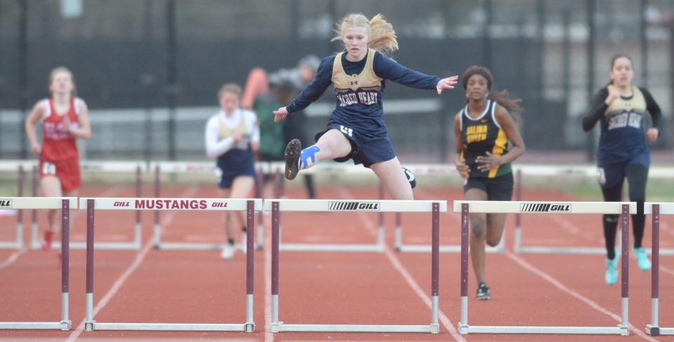 Sacred Heart’s Lauryn Mikkelson jumps on of the hurdles during the girl’s 300 meter hurdles at the Saline County Invitational track meet at the Salina Stadium on Tuesday. Mikkelson finished in first place with a time of 55.16. 