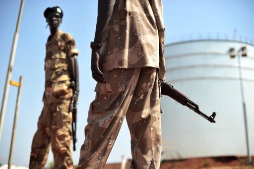 South Sudanese soldiers stand next to crude oil reservoir tanks at a field processing facility in Unity State on November 11, 2010. South Sudan has restarted oil production, ending a bitter 15-month row with former civil war foe Sudan and marking a major breakthrough in relations after bloody border clashes last year