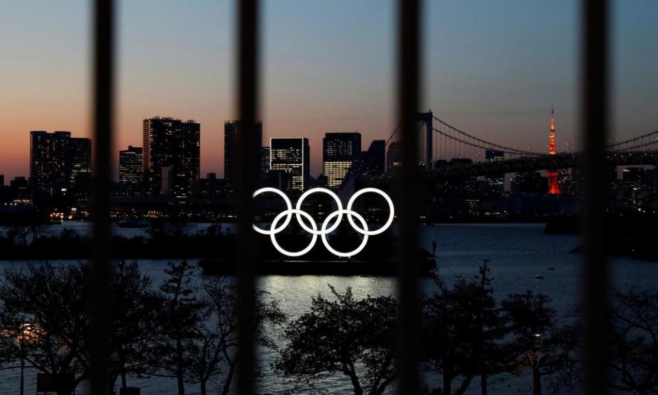 The Olympic rings pictured through a fence in Tokyo.