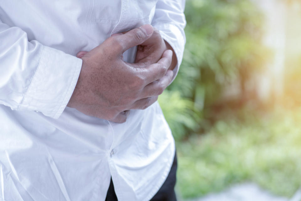 A person gripping their abdomen