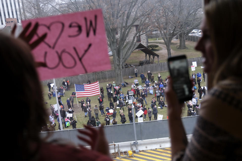 People inside the state house give encouragement to protesters outside the assembly chambers during a protest in Trenton, N.J., Monday, Jan. 13, 2020. The prospects of a vote on legislation to eliminate most religious exemptions for vaccines for schoolchildren in New Jersey looked uncertain Monday, according to the bill's sponsor, as opponents crowded the Statehouse grounds with flags, bullhorns and banners. (AP Photo/Seth Wenig)