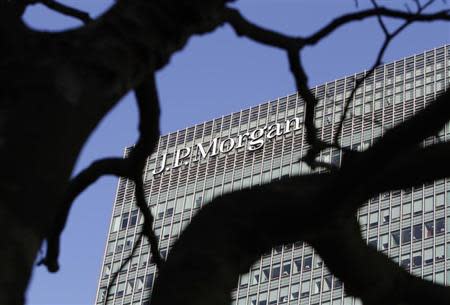 A sign on the Canary Wharf offices of JP Morgan is seen through the branches of a tree in London January 28, 2014. Police said they are investigating the "non-suspicious" death of a man who fell onto a ninth floor roof at the European headquarters of investment bank JP Morgan in London's Canary Wharf on Tuesday morning. REUTERS/Simon Newman