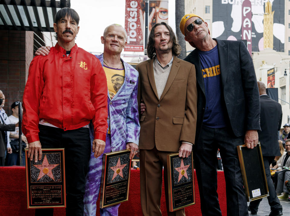 ARCHIVO - Anthony Kiedis, de izquierda a derecha, Flea, John Frusciante y Chad Smith, de Red Hot Chili Peppers, asisten a una ceremonia en honor a la banda para develar su estrella en el Paseo de la Fama de Hollywood el jueves 31 de marzo de 2022 en Los Ángeles. Los Chili Peppers junto con Lauryn Hill y Megan Thee Stallion encabezarán el Global Citizen Festival de este año. La organización sin fines de lucro contra la pobreza busca centrar la atención en la creciente desigualdad para las niñas y mujeres jóvenes en todo el mundo. (Foto Willy Sanjuan/Invision/AP, archivo)