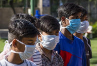 NEW DELHI, INDIA - MARCH 09: Indian children wearing masks amid the COVID-19 coronavirus fear on March 09, 2020 in New Delhi, India. Holi, the 2-day festival of colours will be celebrated across India on March 10. Hindus around the world celebrate Holi to mark the end of the winter and the beginning of the spring. This year amid the rise of coronavirus, the government has called for subdued celebration, with Prime Minister Narendra Modi cancelling a Holi event, the mood on the streets of India seems to hardy have dampened 47 people in India have so far tested positive for the deadly virus. (Photo by Yawar Nazir/ Getty Images)