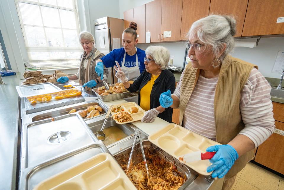 (Left to right) Open Door Café volunteer Judy Wick, Head Cook Lauren Baas, volunteers Karin Sagar and Nimmi Arora serve spaghetti for the free hot lunch program at the Cathedral of St. John the Evangelist on Thursday April 4, 2024 in Milwaukee, Wis.