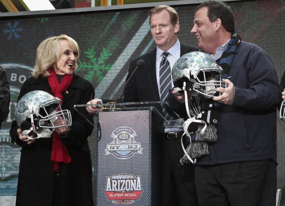 NFL Commissioner Roger Goodell, center, stands between Arizona Gov. Jan Brewer, left, and New Jersey Gov. Chris Christie, right, showoff souvenir football helmets after a ceremony to pass official hosting duties of next year's Super Bowl to Arizona, Saturday Feb. 1, 2014 in New York. (AP Photo/Bebeto Matthews)