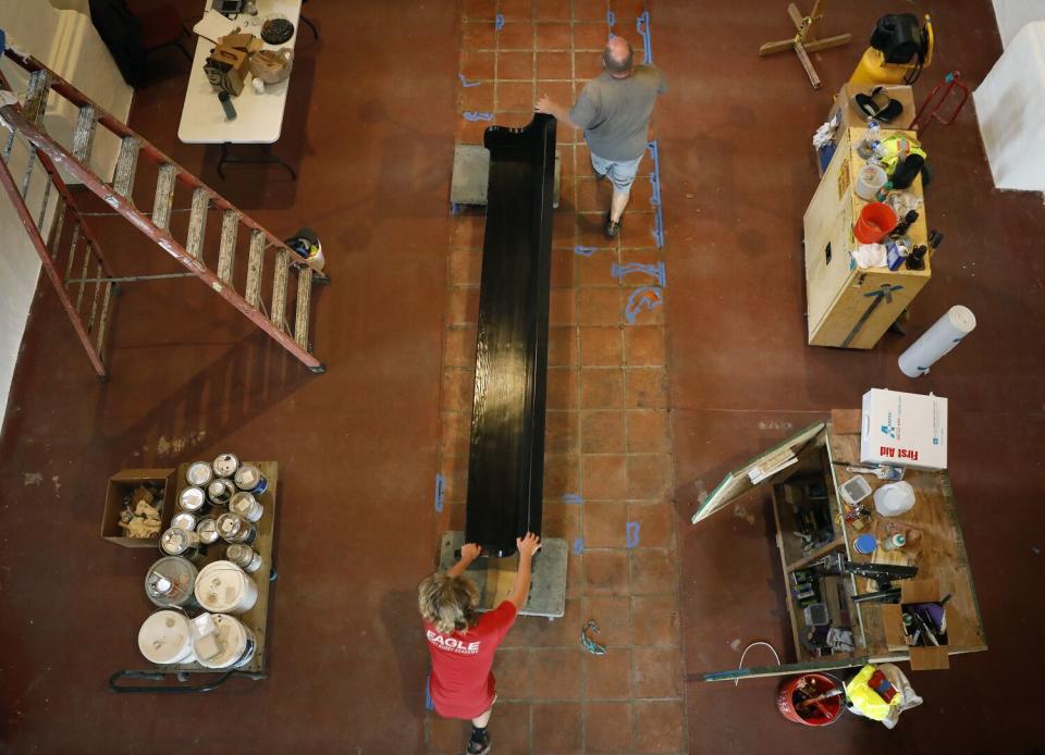 Pews are moved inside the San Gabriel Mission.