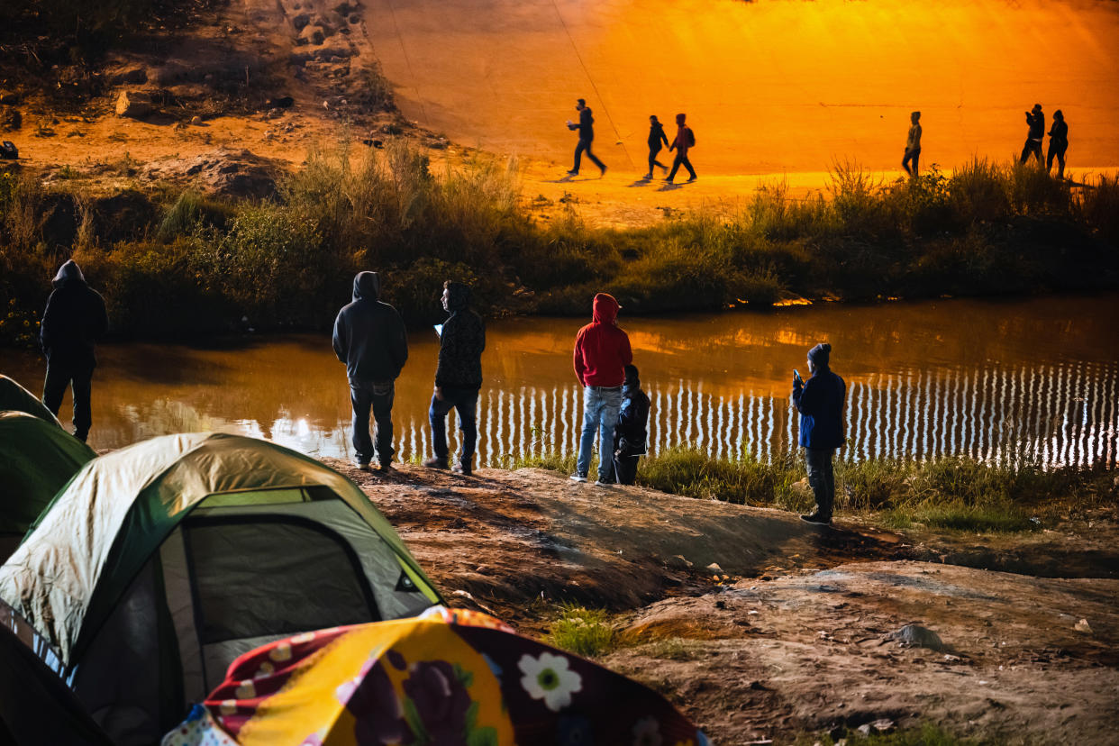 Un grupo de migrantes del lado estadounidense del río Bravo caminan para entregarse a agentes de la Patrulla Fronteriza cerca de El Paso, Texas, el martes 15 de noviembre de 2022. (Justin Hamel/The New York Times)