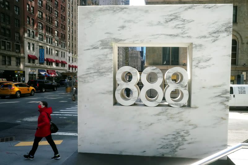 FILE PHOTO: A person walks past 888 7th Ave, a building that reportedly houses Archegos Capital in New York City