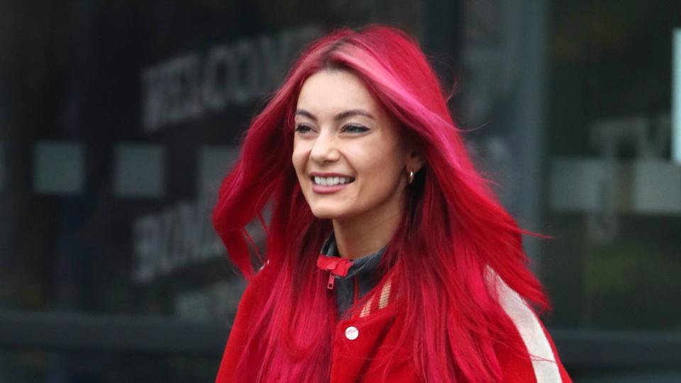 Dianne walking in red jacket with pink streaks in hair