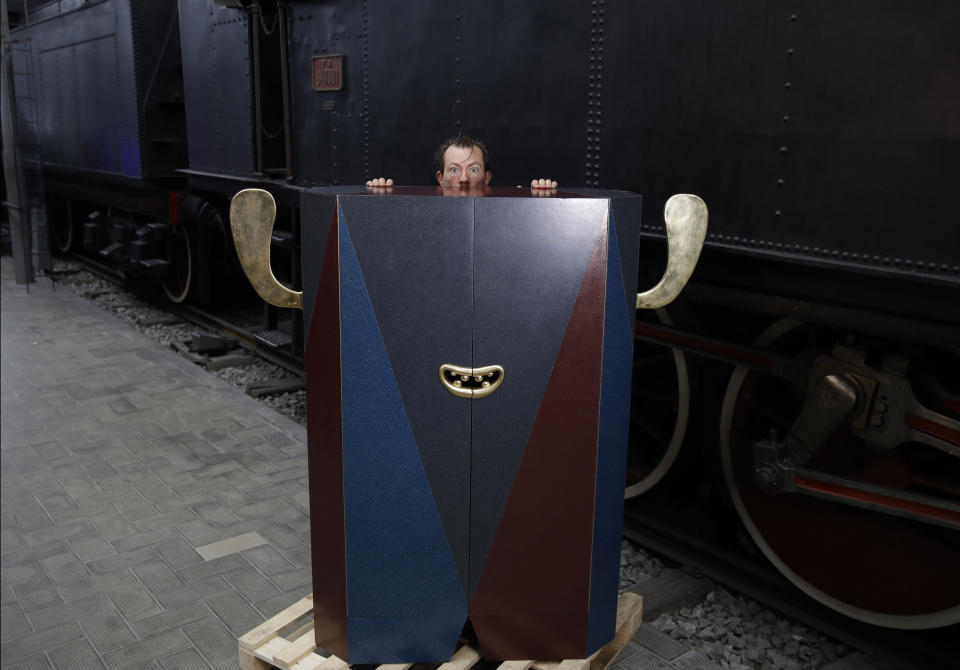 In this picture taken on Saturday, April 13, 2019, Italian designer Matteo Cibic poses next to his creation ''Cabinet -oh', made with recycled packaging plastic, at the National Museum of Science and Technology, during the "RO Plastic - Master's Pieces" exhibition', on the sidelines of the Salone del Mobile International Furniture Fair week, in Milan, Italy. Scientists and environmental activists have been long raised the alarm on plastic pollution. Now, the high-end design world is getting in on the growing global effort to tackle plastic pollution -- by upcycling discarded objects into desirable one-off design pieces. (AP Photo/Luca Bruno)