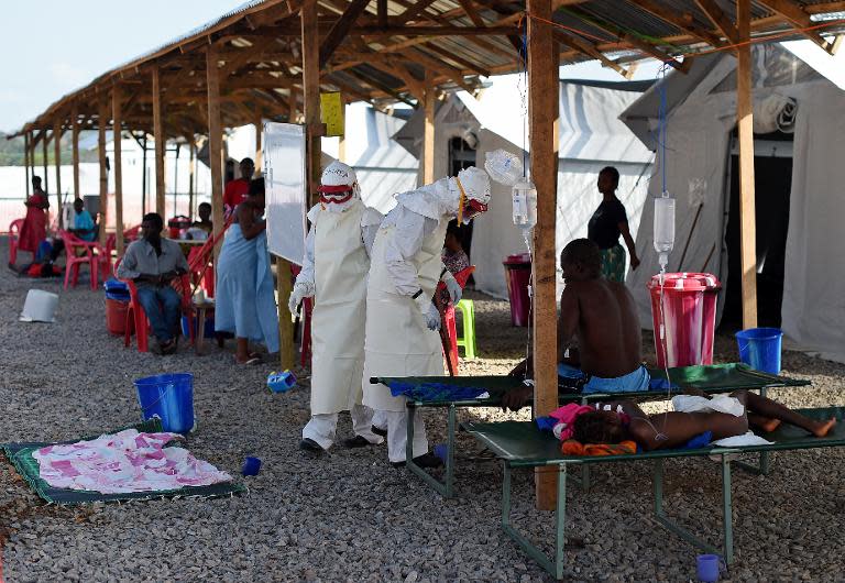 File picture taken on November 15, 2014 shows nurses wearing personal protective equipment while treating ebola patients at the Kenama treatment center run by the Red Cross Society, in eastern Sierra Leone