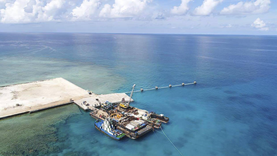 In this handout photo provided by the Department of National Defense PAS, ships carrying construction materials are docked at the newly built beach ramp at the Philippine-claimed island of Pag-asa, also known as Thitu, in the disputed South China Sea on Tuesday June 9, 2020. The Philippine defense chief and top military officials flew to a disputed island in the South China Sea Tuesday to inaugurate a beach ramp built to allow the "full-blast" development of the far-flung territory but would likely infuriate China. (Department of National Defense PAS via AP)