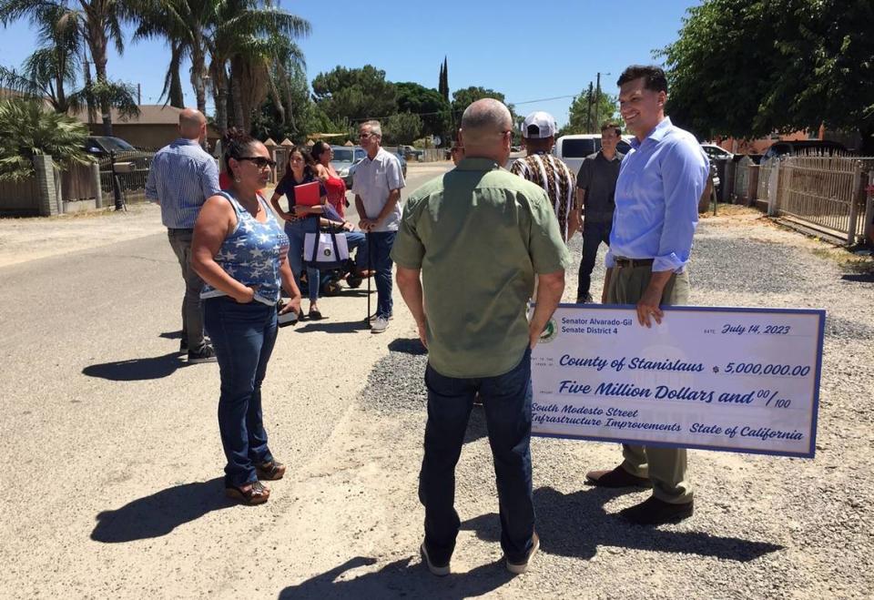 Stanislaus County Board of Supervisors then-Chairman Channce Condit holds a ceremonial check in July 2023 while talking with constituents about state funding for south Modesto street improvements. State Sen. Marie Alvarado-Gil secured the $5 million in funding.