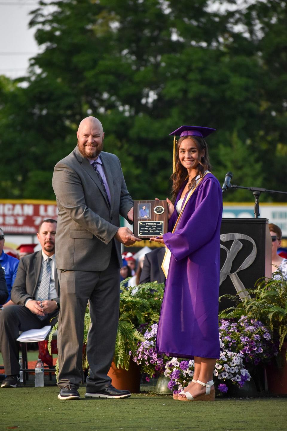 Jason Vesey, director of Secondary Education, presents the Student of the Year plaque to Roxanne Storts-Berio.