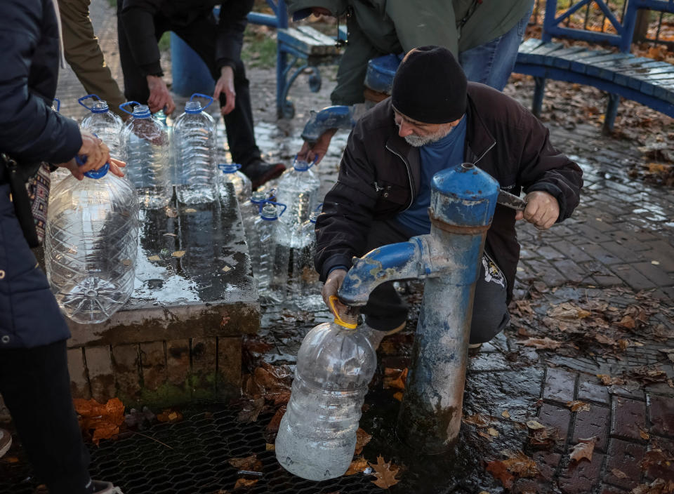 A man fills a gallon as local residents queue for water after about 80 percent of the inhabitants of the Ukrainian capital were left without water supply according to the mayor, after a Russian missile attack, as Russia's invasion of Ukraine continues, in Kyiv, Ukraine October 31, 2022.  REUTERS/Gleb Garanich