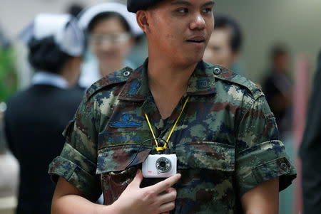 A Thai military personnel uses a video camera to make a record of visitors at an entrance of the Phramongkutklao Hospital in Bangkok, Thailand, May 23, 2017. REUTERS/Chaiwat Subprasom