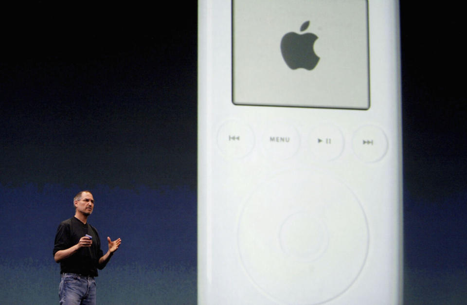 Steve Jobs stands by the projection of an iPod at a 2004 event launching the iTunes Music Store in Great Britain, Germany, and France. (Photo credit: Ian Waldie/Getty Images)