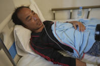 Survivor Zhu Pingfan, 41, from Hunan province, China, recuperates in a hospital bed, Saturday, Sept. 24, 2022, Preah Sihanouk Province, Southwestern Cambodia after being rescued from a sinking boat days earlier. Authorities are searching for multiple people in the surrounding waters after their boat sank near Cambodia's Koh Tang island on Thursday. (AP Photo/Heng Sinith)