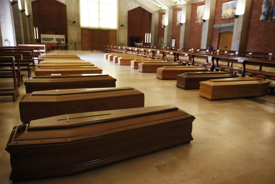 FILE - In this March 26, 2020 file photo, coffins are lined up on the floor in the San Giuseppe church in Seriate, one of the areas worst hit by coronavirus, near Bergamo, Italy, waiting to be taken to a crematorium. Italy is poised to reclaim the dishonor of reporting the most coronavirus deaths in Europe, as the second surge ravages the country’s disproportionately old population and exposes how public health shortfalls and delayed restrictions compounded a lack of preparedness going into the pandemic. (AP Photo/Antonio Calanni, file)