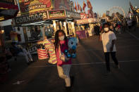 A girl wears a face mask while walking through the Mississippi State Fair, Wednesday, Oct. 7, 2020, in Jackson, Miss. At the fair, which is held every year in October and attracts people from across the racial spectrum, the vast majority of Black people are wearing masks. Most white people do not. (AP Photo/Wong Maye-E)