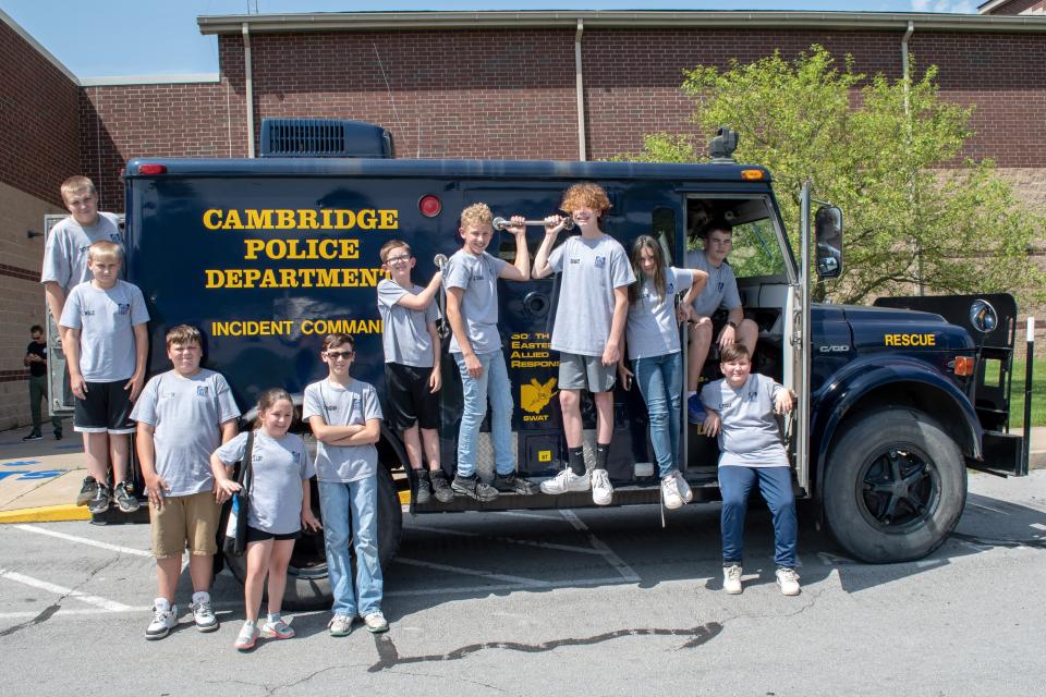 The Cambridge Police Youth Citizens Academy students gather around the CPD Incident Command Vehicle, also known as the Hippo.