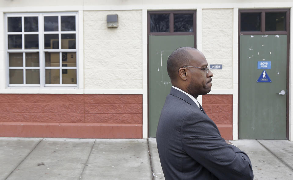 Charles Ramsey, president of the West Contra Costa school board, stands outside of the boys bathroom where police were investigating reports of a brutal assault of a transgender teen at the Hercules Middle-High School campus in Hercules, Calif., Tuesday, March 4, 2014. The 15-year-old student told officers he was leaving a boy's bathroom at Hercules High School on Monday when three teenage boys pushed him inside a handicapped stall and physically and sexually assaulted him, Hercules police Detective Connie Van Putten said. (AP Photo/Jeff Chiu)