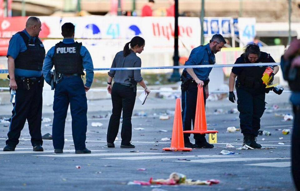 Police officers investigate the scene of a shooting where at least one person was killed and more than 20 others were injured after the Kansas City Chiefs Super Bowl LVIII victory parade Wednesday, Feb. 14, 2024, in Kansas City.