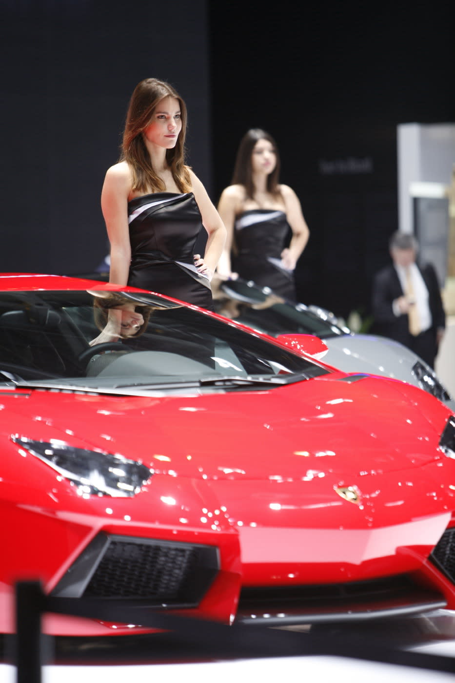 Lamborghini booth models pose for cameras at the 2013 Geneva Motor Show.