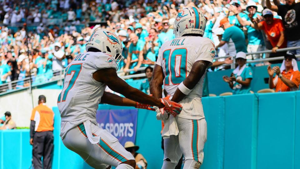 Jaylen Waddle helps team-mate Tyreek Hill celebrate his touchdown by pretending to handcuff him