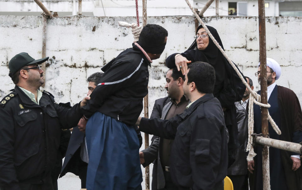 FILE - This Tuesday, April 15, 2014, file picture provided by ISNA, a semi-official news agency, shows Iranian woman Samereh Alinejad, right, slapping blindfolded Bilal, who was convicted of murdering her son Abdollah prior to his execution in public in the northern city of Nour, Iran. Her son’s killer stood shackled on a chair on the gallows, the noose around his neck. Hundreds crowded outside the jailhouse in this northern Iranian town to see if Samereh Alinejad would exercise her right to kick the chair out from under him to let him hang. Alinejad tells The Associated Press that she had felt she could never live with herself if the man who killed her son were spared. But in the last moment, she pardoned him in an act that has made her a hero in her hometown, where banners in the streets praise her family’s mercy. (AP Photo/ISNA, Arash Khamoushi, File)