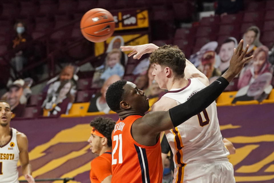 Minnesota's Liam Robbins (0) passes the ball as Illinois' Kofi Cockburn (21) defends in the first half of an NCAA college basketball game, Saturday, Feb. 20, 2021, in Minneapolis. (AP Photo/Jim Mone)