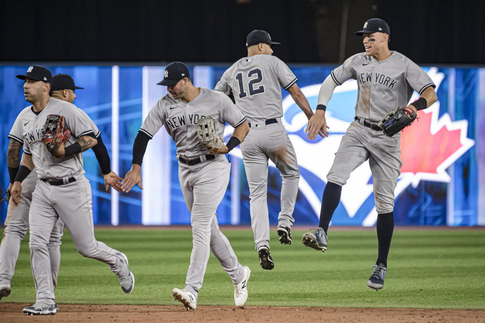 New York Yankees center fielder Aaron Judge, right, and shortstop Isiah Kiner-Falefa (12) celebrate with teammates after defeating the Toronto Blue Jays 12-3 in a baseball game Friday, June 17, 2022, in Toronto. (Christopher Katsarov/The Canadian Press via AP)