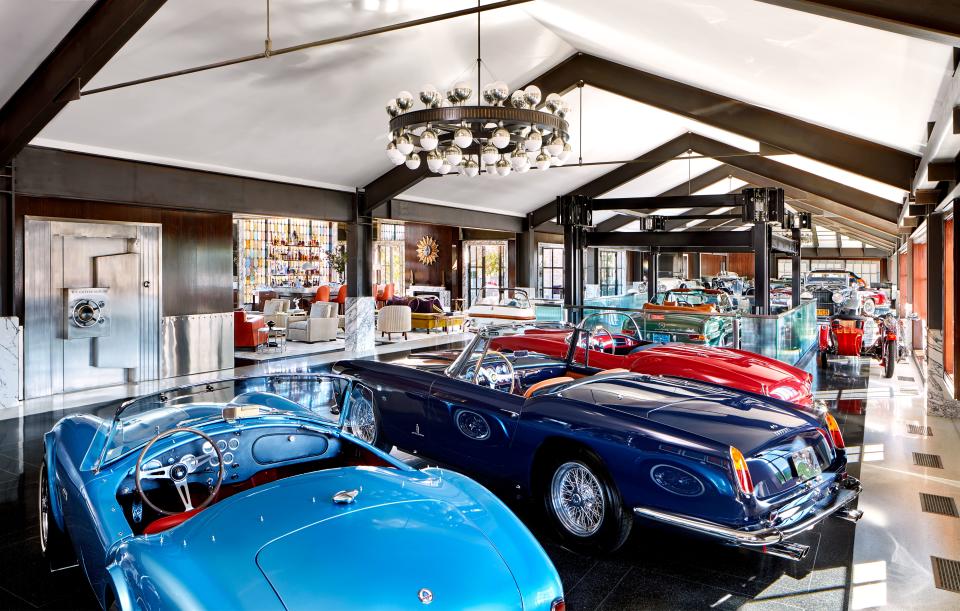 A light-blue 1964 Shelby Cobra, a dark-blue 1960 Ferrari, and a red 1955 Lancia are just three of the automotive treasures housed here. Custom polished nickel-and-bronze chandelier by Dank Fink Studio.