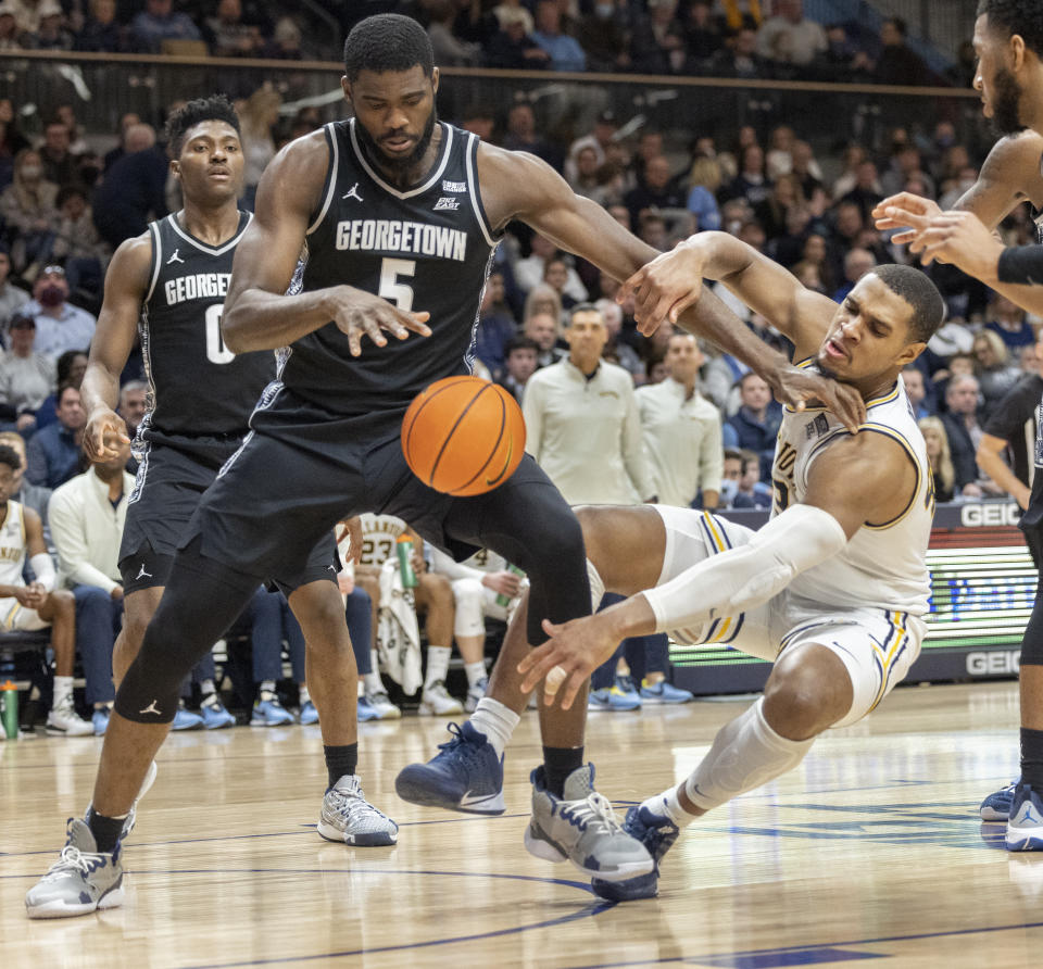 Georgetown center Timothy Ighoefe (5) and Villanova forward Eric Dixon (43) chase a rebound during the second half of an NCAA college basketball game, Saturday, Feb. 19, 2022, in Villanova, Pa. (AP Photo/Laurence Kesterson)