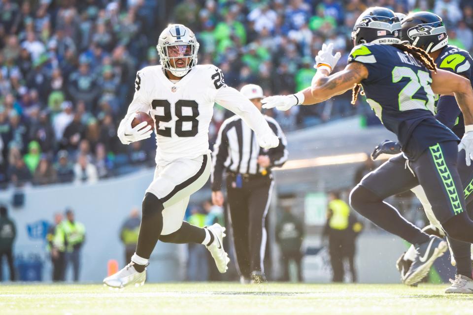 El corredor de los Raiders de Las Vegas, Josh Jacobs (28), corre contra los Seahawks de Seattle.