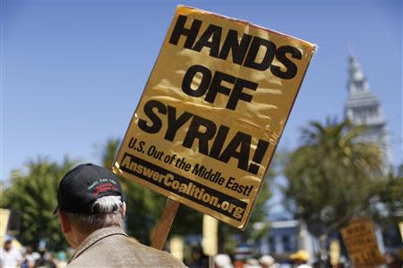 A demonstrator holds a sign rally during an anti-war rally in San Francisco, California September 7, 2013. REUTERS/Stephen Lam