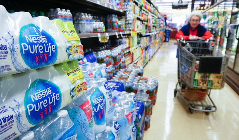 A woman pushes her shopping cart down the bottled water aisle at a supermarket in Los Angeles, California on March 15, 2018. The world's leading brands of bottled water are contaminated with tiny plastic particles that are likely seeping in during the packaging process, according to a major study across nine countries. Plastic was identified in 93 percent of the samples, which included major name brands such as Aqua, Aquafina, Dasani, Evian, Nestle Pure Life and San Pellegrino. / AFP PHOTO / FREDERIC J. BROWN (Photo credit should read FREDERIC J. BROWN/AFP via Getty Images)