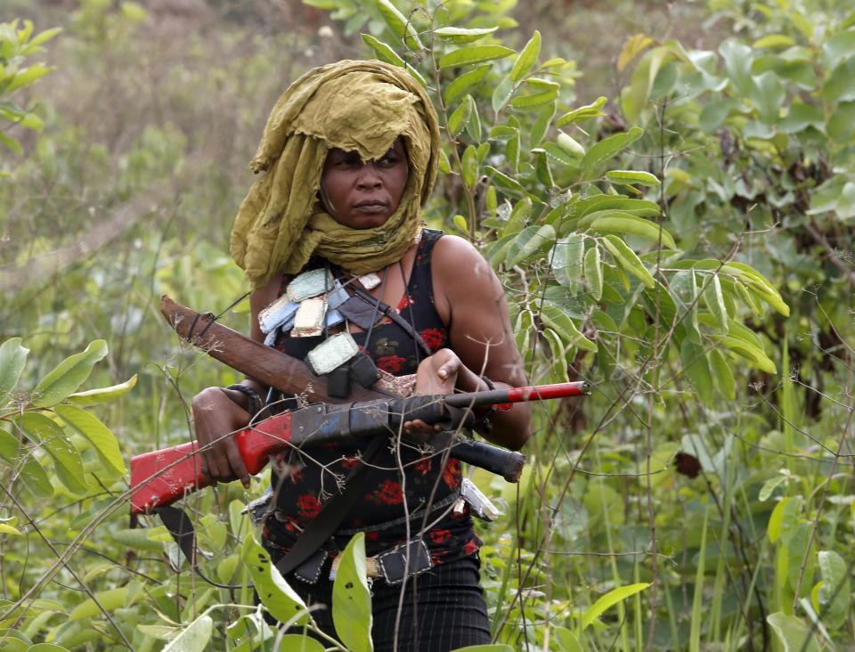 A female member of the anti-balaka, a Christian militia, patrols with other militiamen outside village of Zawa