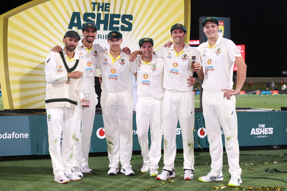 The Australian bowlers Nathan Lyon, Mitchell Starc, Scott Boland, Jhye Richardson, Pat Cummins and Cameron Green pose with the Ashes urn.