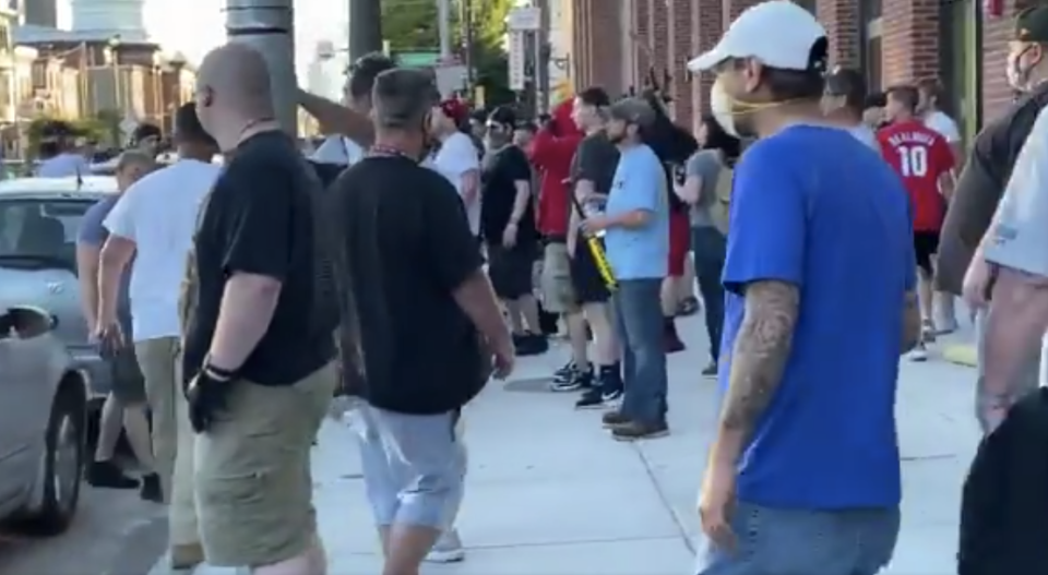 Men with weapons stand on the side of the street in confronation with protesters. Source: Twitter/ John Ehrens