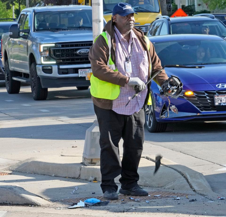 A City of Milwaukee Department of Public Works employee pics up debris off the street after a vehicle accident left four people dead near the corner of North 60th street and West Fond Du Lac Avenue in Milwaukee on Monday, May 15, 2023.
